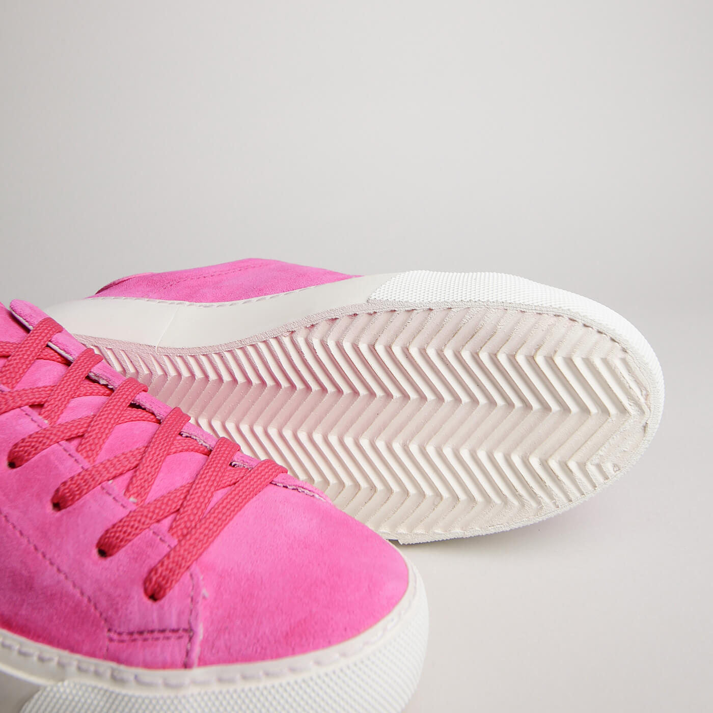Close-up of fuchsia suede, laces and herringbone outsole on the women’s Milano
