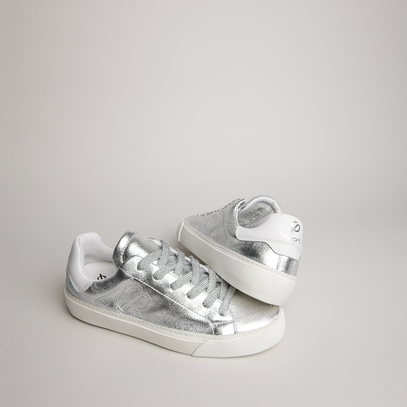 Angled pair of women’s silver goat leather Milano sneakers
