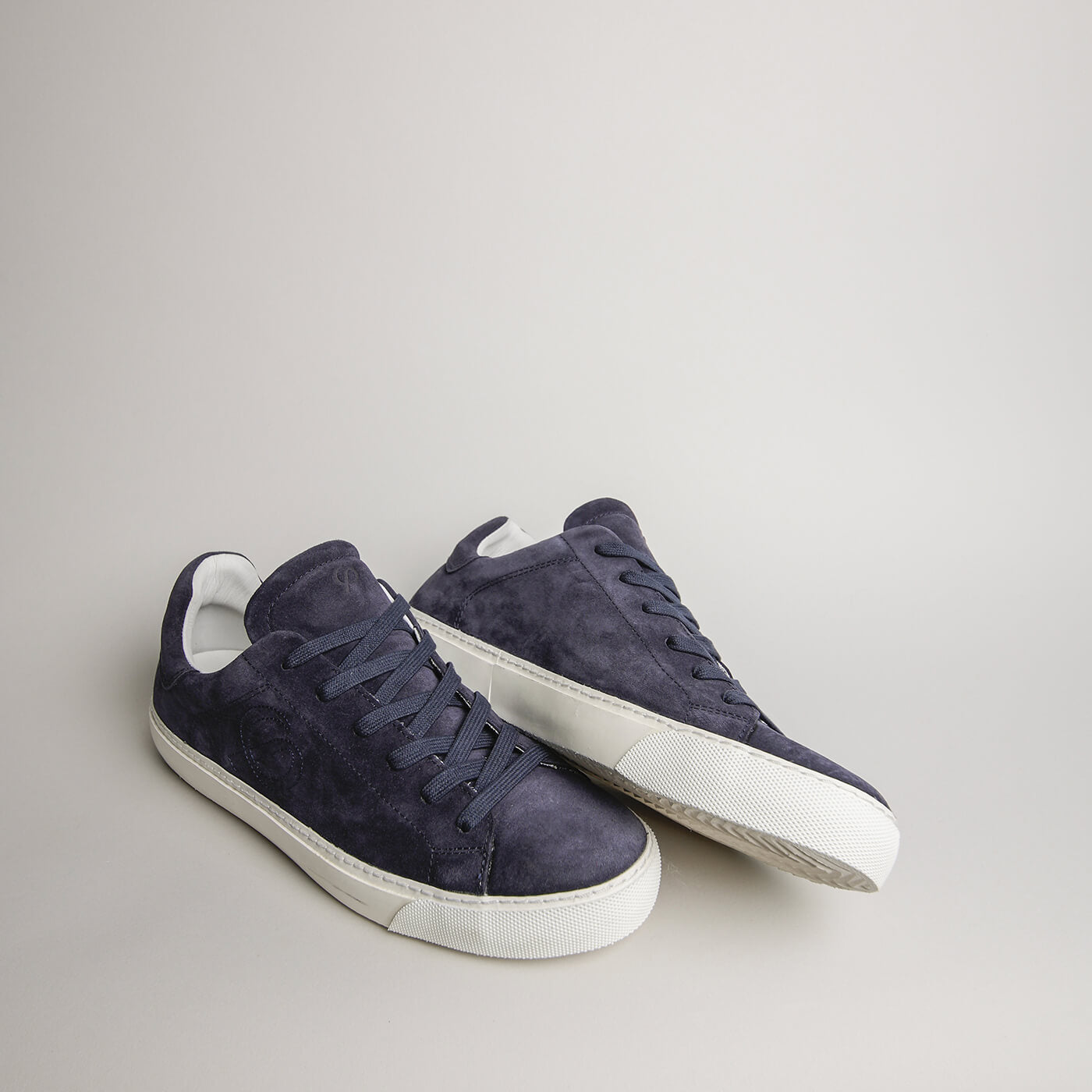 Angled pair of men’s navy blue suede Milano sneakers