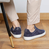 Man wearing navy blue suede Milano sneakers, rear view