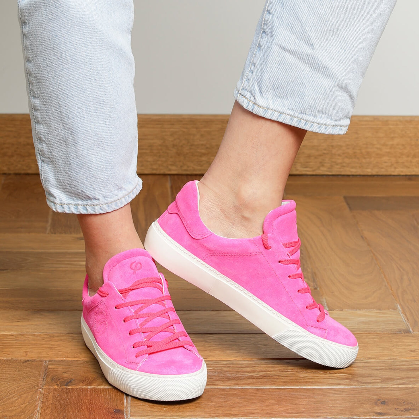 Woman wearing fuchsia suede Milano sneakers with white rubber soles
