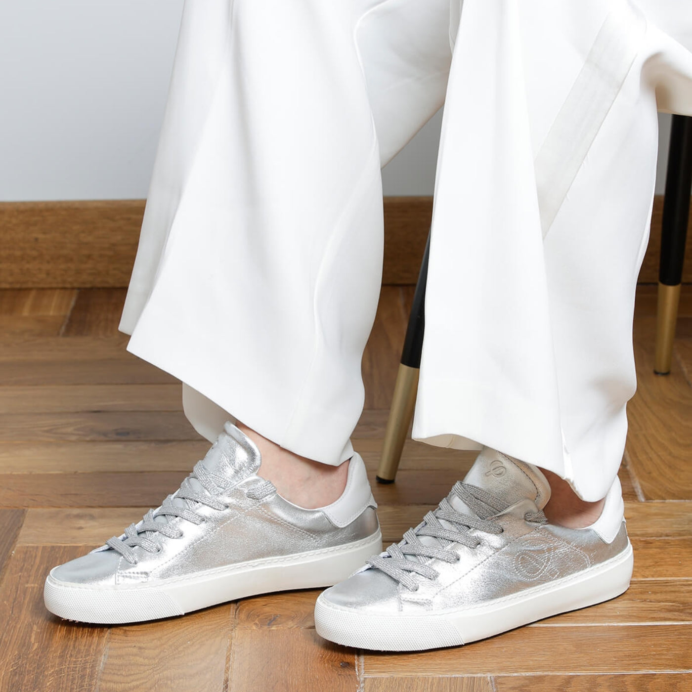 Woman wearing silver goat leather Milano sneakers, side view