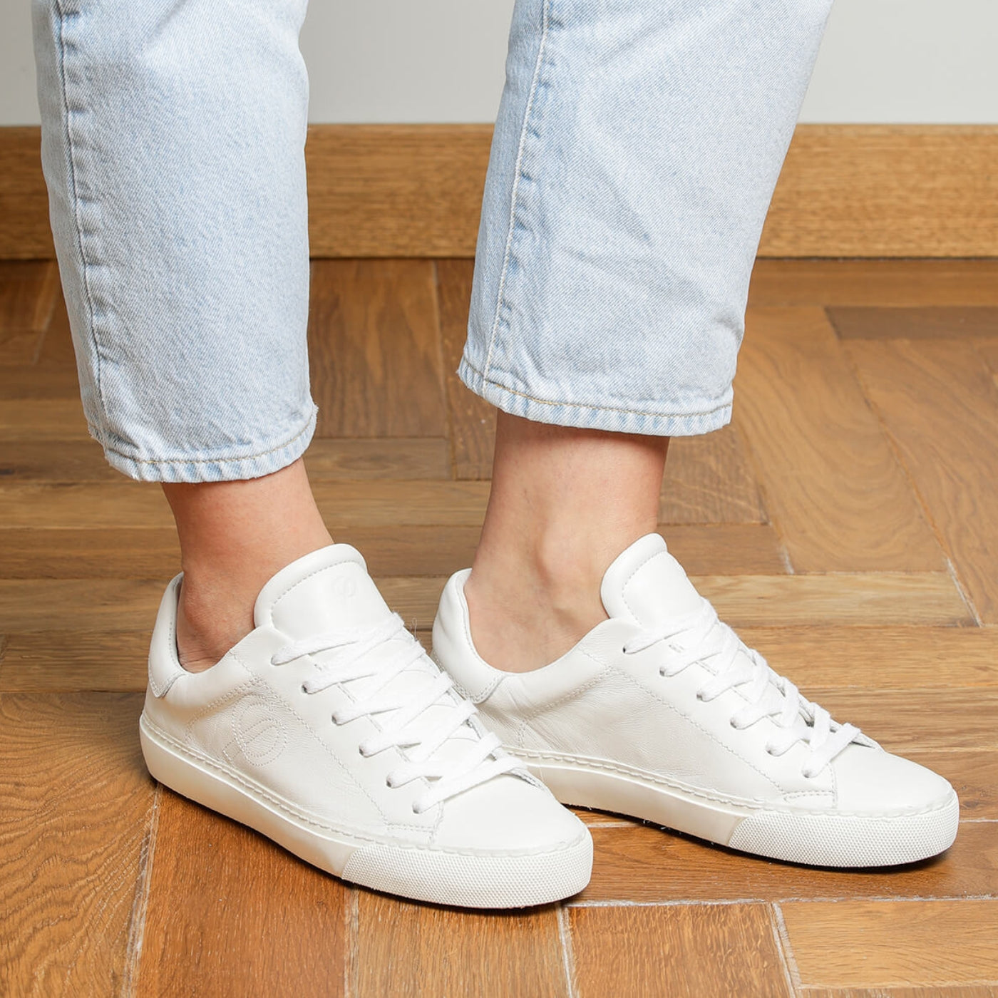 Woman wearing white goat leather Milano sneakers, side view