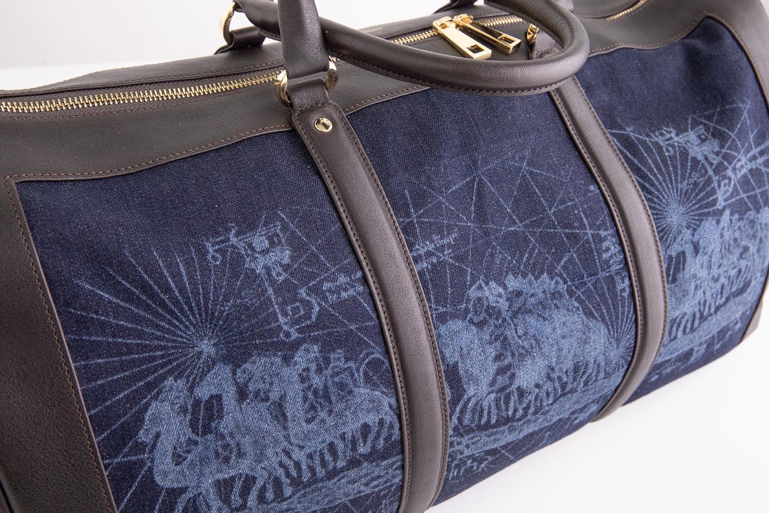 Close-up of the Weekend Bag's printed navy denim and brown leather trim